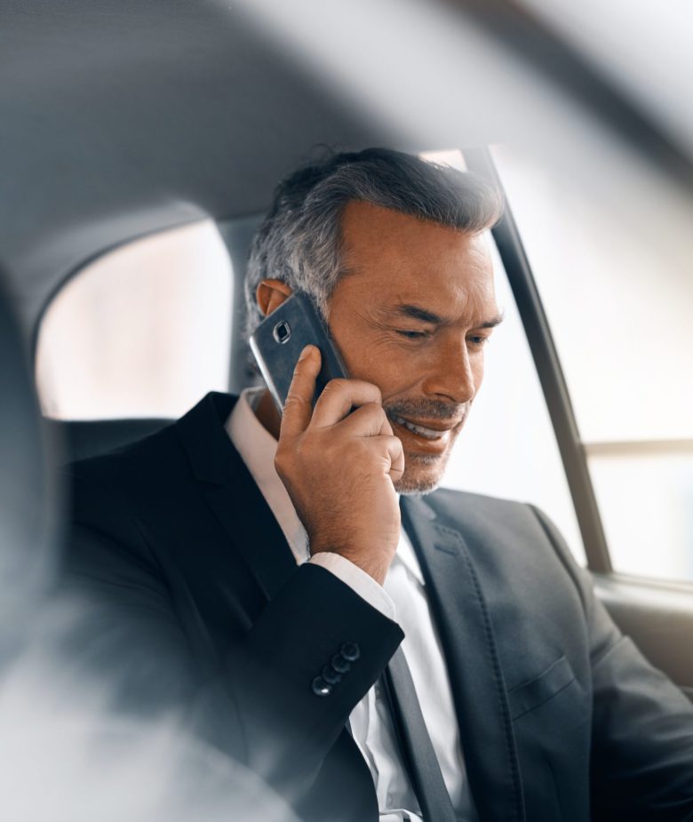 Cropped shot of a handsome mature businessman making a call from the backseat of a car during his morning commute.